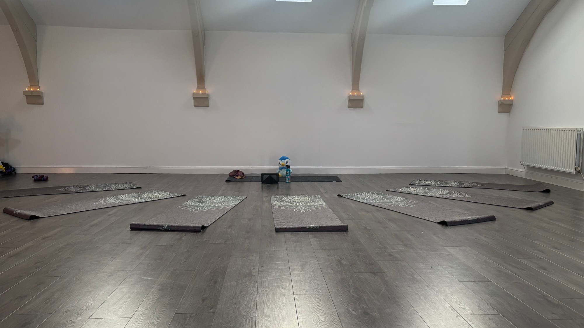 A quiet yoga studio prepared for a group yoga nidrā practice, with mats laid out
